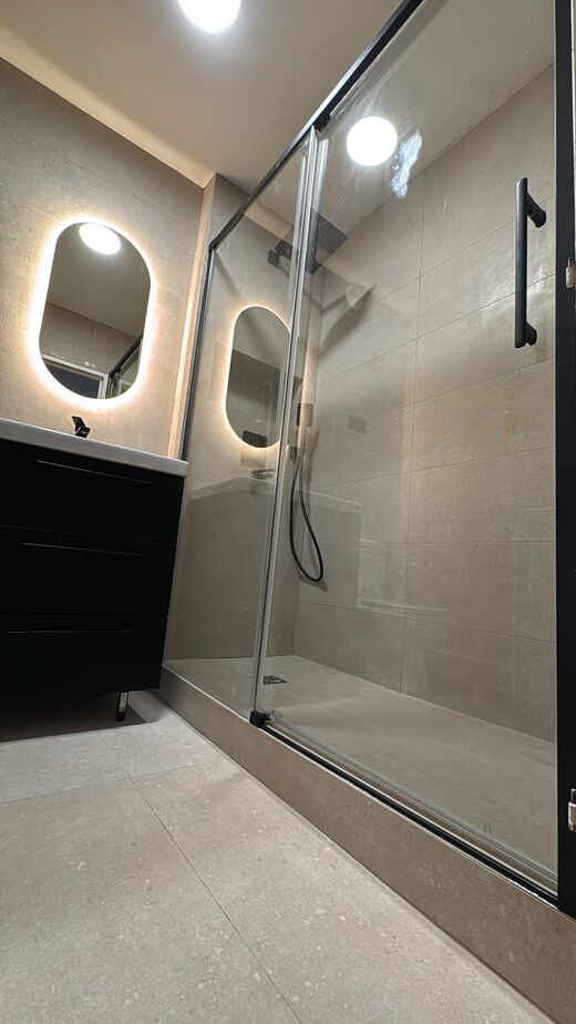 Salle de bain rénovée — carrelage grand format et douche à l'italienne